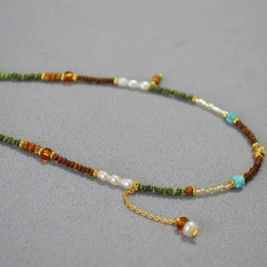 Détail macro d'un collier de perles fait main avec perles d'eau douce et turquoise
