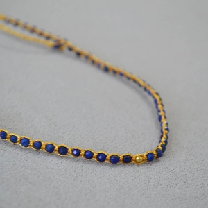 Vue détaillée du bracelet fait main en perles de lapis-lazuli avec tissage fil doré
