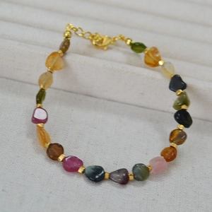 Detail of colorful irregular tourmaline beads necklace with golden spacers and lobster clasp