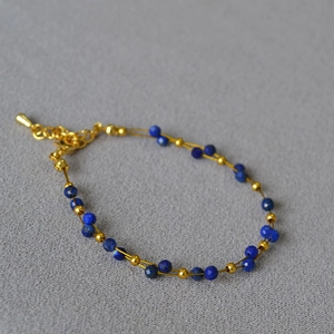 Detailed view of double-layer lapis lazuli beaded bracelet with gold chain and lobster clasp