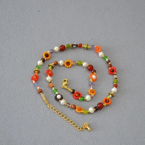 Collier bohème fait main en perles colorées avec motif floral et fermoir doré chic