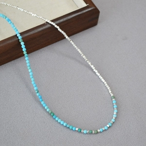 Detail of turquoise beads and silver square spacers on a stylish minimalist necklace