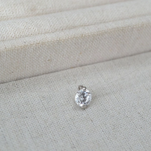 Vue macro d'un pendentif en zircone flottant minimaliste sur une chaîne en fil invisible