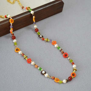 Détail d'un collier bohème avec perles en verre colorées et fleurs faites à la main