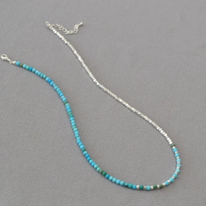 Detail of silver beads and turquoise stones necklace with metal lobster clasp and chain