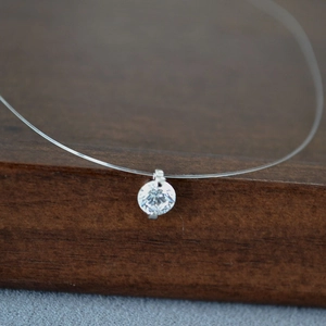 Vue macro d'un pendentif en zircone cubique étincelant sur un fil de pêche invisible