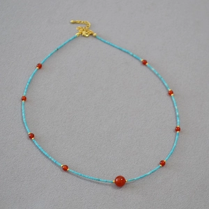 Ethnic beaded necklace with turquoise tubes, red agate beads and golden adjustable clasp