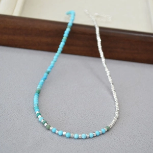 Close-up of turquoise and silver faceted beads on a summer style beaded necklace