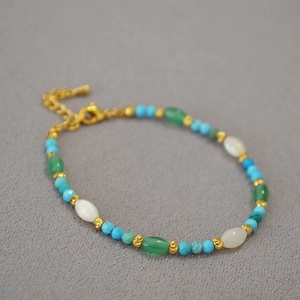 Bohemian beaded bracelet featuring turquoise and gold accents on a textured fabric background