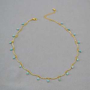 Detail of gold-plated brass chain featuring faceted turquoise beads and lobster clasp