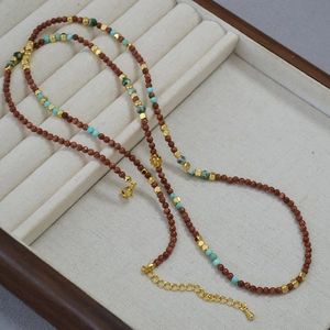 Detail of vintage beaded necklace with goldstone turquoise and metallic spacer beads