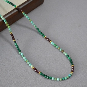 Détail d'un collier vintage avec perles de malachite turquoise et séparateurs dorés