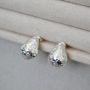 Sparkling teardrop stud earrings with multifaceted geometric surface in silver plating