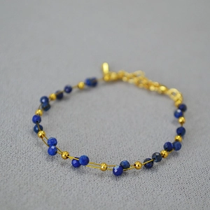 Detail of double-strand lapis lazuli beaded bracelet with gold accents and lobster clasp