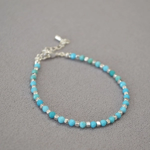 Detail of turquoise beaded bracelet featuring silver square spacers and adjustable clasp