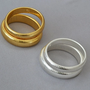 Detailed view of flexible gold and silver plated brass ribbed Tubogas snake bracelets