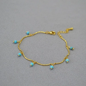 Detail of gold-plated brass chain with faceted turquoise beads and lobster clasp closure