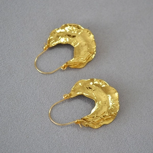 Detailed view of gold plated earrings featuring a vintage hammered irregular lava texture
