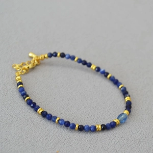 Dettaglio della collana di perle blu sfaccettate con distanziatori dorati e chiusura
