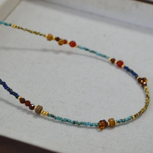Macro view of handmade retro beaded necklace with turquoise beads and red agate accents