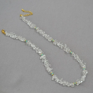 Close-up of clear crystal and turquoise beaded necklace with golden lobster clasp