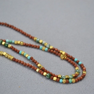 Macro shot of retro beaded necklace with goldstone turquoise and clover pendant charm