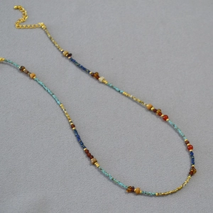 Macro detail of French retro beaded necklace with turquoise and red agate stones