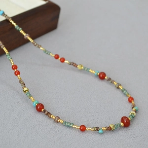 Close-up detail of vintage red agate beads and turquoise accents on minimalist necklace