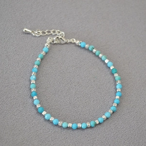Macro view of blue turquoise beaded bracelet with silver spacers and lobster clasp