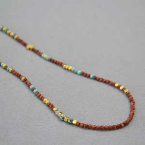 Close-up of vintage brown goldstone and turquoise beads on an elegant necklace