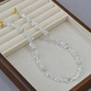 Detail of irregular white quartz chips necklace with turquoise beads and gold clasp