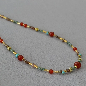 Macro view of colorful red agate and turquoise beads on an ethnic style necklace