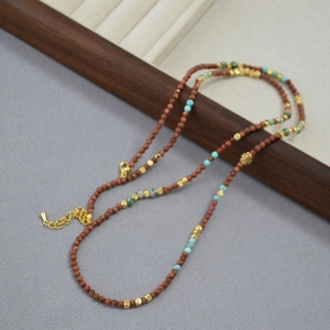 Detail of goldstone and turquoise beaded necklace with adjustable gold-tone lobster clasp