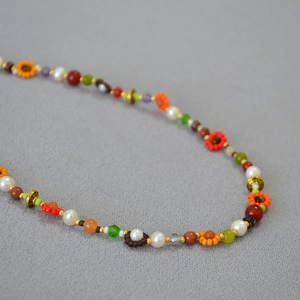 Détail du collier bohème avec perles d'eau douce, fleurs en verre et pierres naturelles