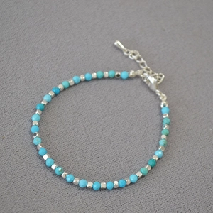 Detail view of turquoise faceted beads and silver square spacers on a bohemian bracelet
