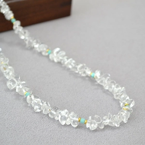 Detail of irregular white crystal and amazonite beaded necklace with golden spacers