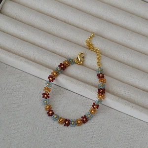 Handmade bohemian beaded flower bracelet with sunset colors and gold adjustable chain
