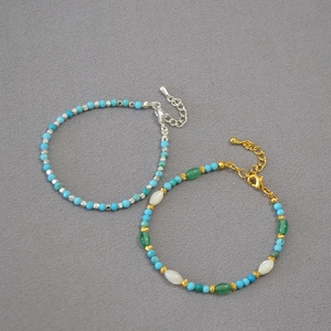 Detail of beaded turquoise bracelets with silver accents and adjustable lobster clasp