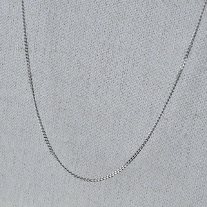 Detailed view of silver minimalist stainless steel curb chain with high polished finish