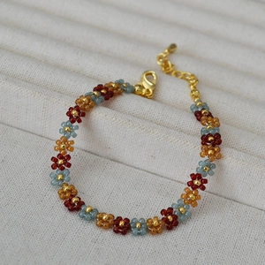 Detail of bohemian handmade beaded flower bracelet with sunset colors and lobster clasp