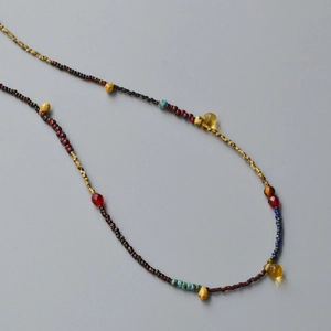 Detailed view of bohemian beaded necklace with yellow teardrop pendant and turquoise beads