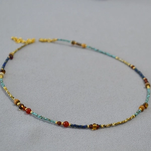 Macro detail of French retro necklace with green turquoise and red agate beaded textures