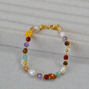 Detail of colorful beaded necklace featuring freshwater pearls and small flower beads