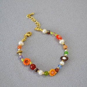 Détail du collier bohème avec fleurs tissées et fermoir mousqueton en métal doré