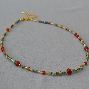 Detail of red agate and turquoise beaded necklace with gold lobster clasp and extension