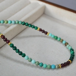 Détail macro de perles naturelles de malachite et turquoise sur un support texturé