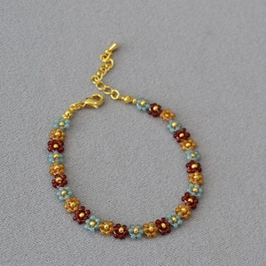 Detail of bohemian handmade beaded flower bracelet with gold lobster clasp and chain