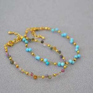 Detail of double-layer gold chain bracelets with colorful lapis lazuli and lobster clasp