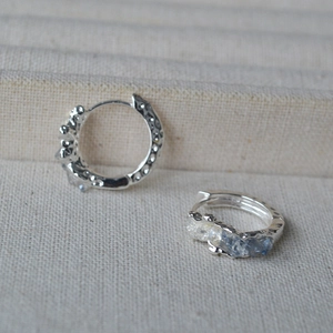 Minimalist silver hoop earrings with hammered texture and blue zircon accents