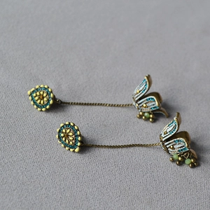 Detail of vintage flower tassel earrings with turquoise accents and gold plating